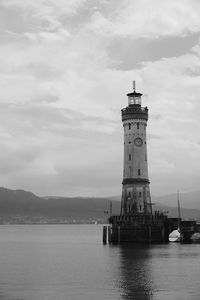 Lighthouse by sea against sky