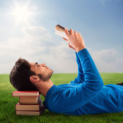 Side view of young man lying on field