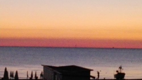 Scenic view of sea against romantic sky at sunset