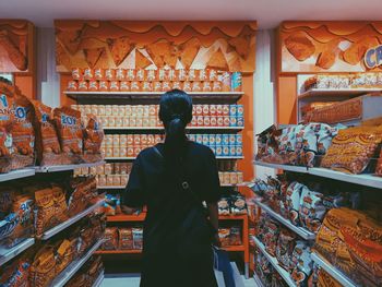 Rear view of man standing at store