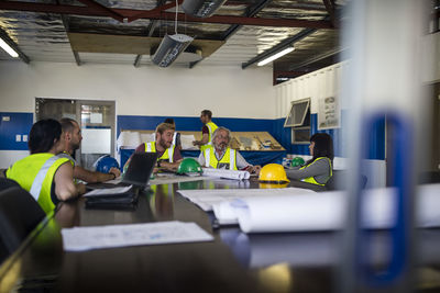 Construction worker and engineer discussing project in site office