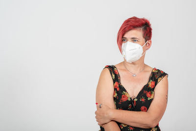 Portrait of woman standing against white background