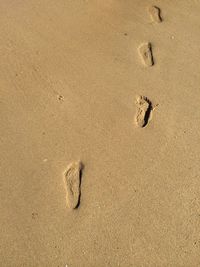 High angle view of footprints on sand at beach