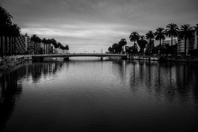 Scenic view of river against sky in city