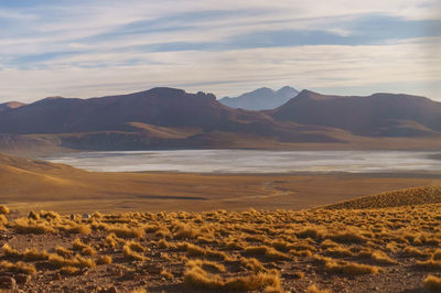 Scenic view of sea and mountains against sky