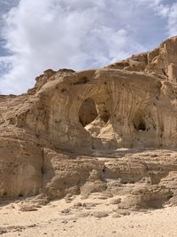 Rock formations against cloudy sky