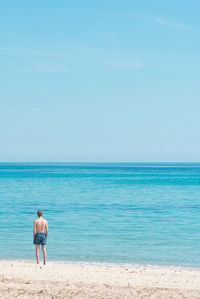 Rear view of man standing on beach