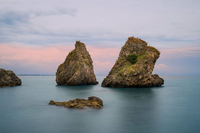 Cliffs in sea against sky