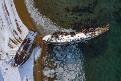 High angle view of sailboats moored on sea during winter
