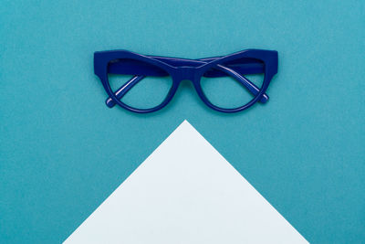 High angle view of eyeglasses on blue table