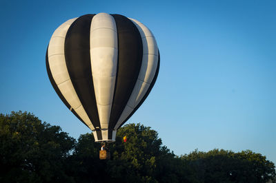 Low angle view of hot air balloon against clear blue sky