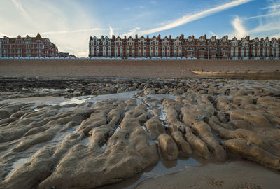 Rocks at shore against buildings in city