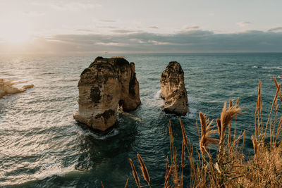 Rocks on sea shore against sky