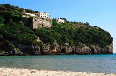 Castle by sea against clear blue sky