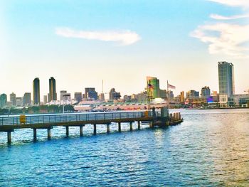 Bridge over river in city against sky