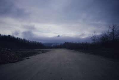 Road amidst trees against sky