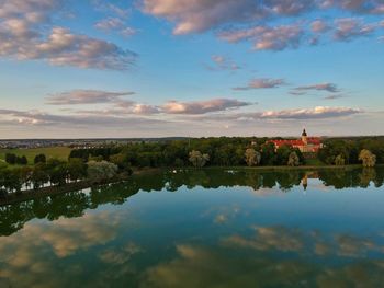 Scenic view of lake by buildings against sky