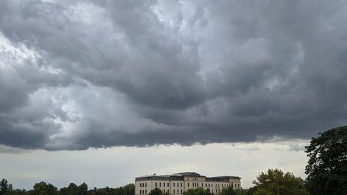 Low angle view of building against storm clouds