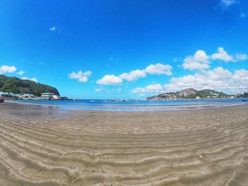 Scenic view of beach against blue sky