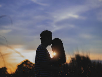 Silhouette woman standing against sky during sunset