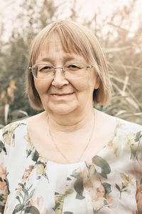 An elderly woman in the tall grass with spikelets. autumn.