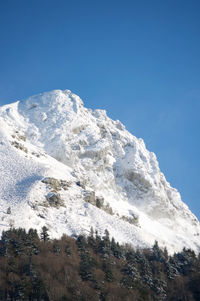 Low angle view of snowcapped mont sancy mountain in auvergne france against clear blue sky