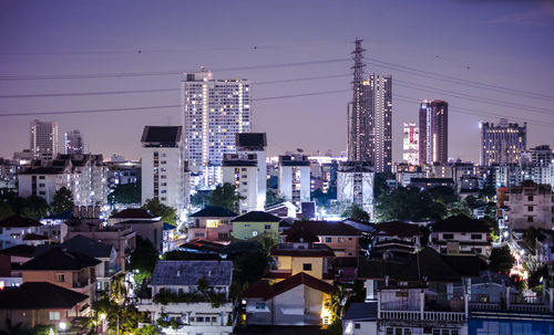 Illuminated buildings in city against sky at night