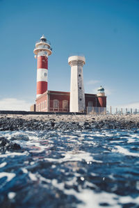 View of lighthouse on beach against sky