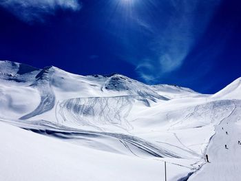 Scenic view of snow mountains against blue sky