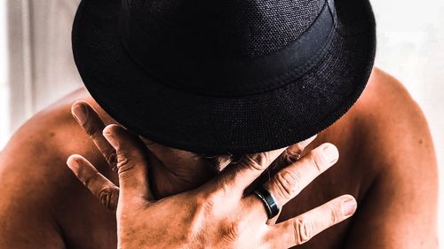 Close-up of man holding hat