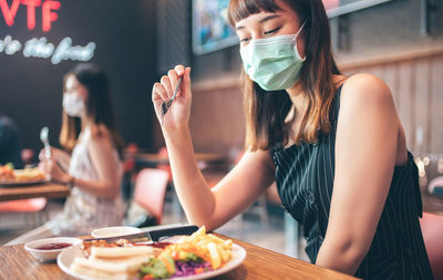 Midsection of woman having food at restaurant