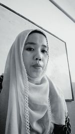 Close-up portrait of young woman sitting in classroom