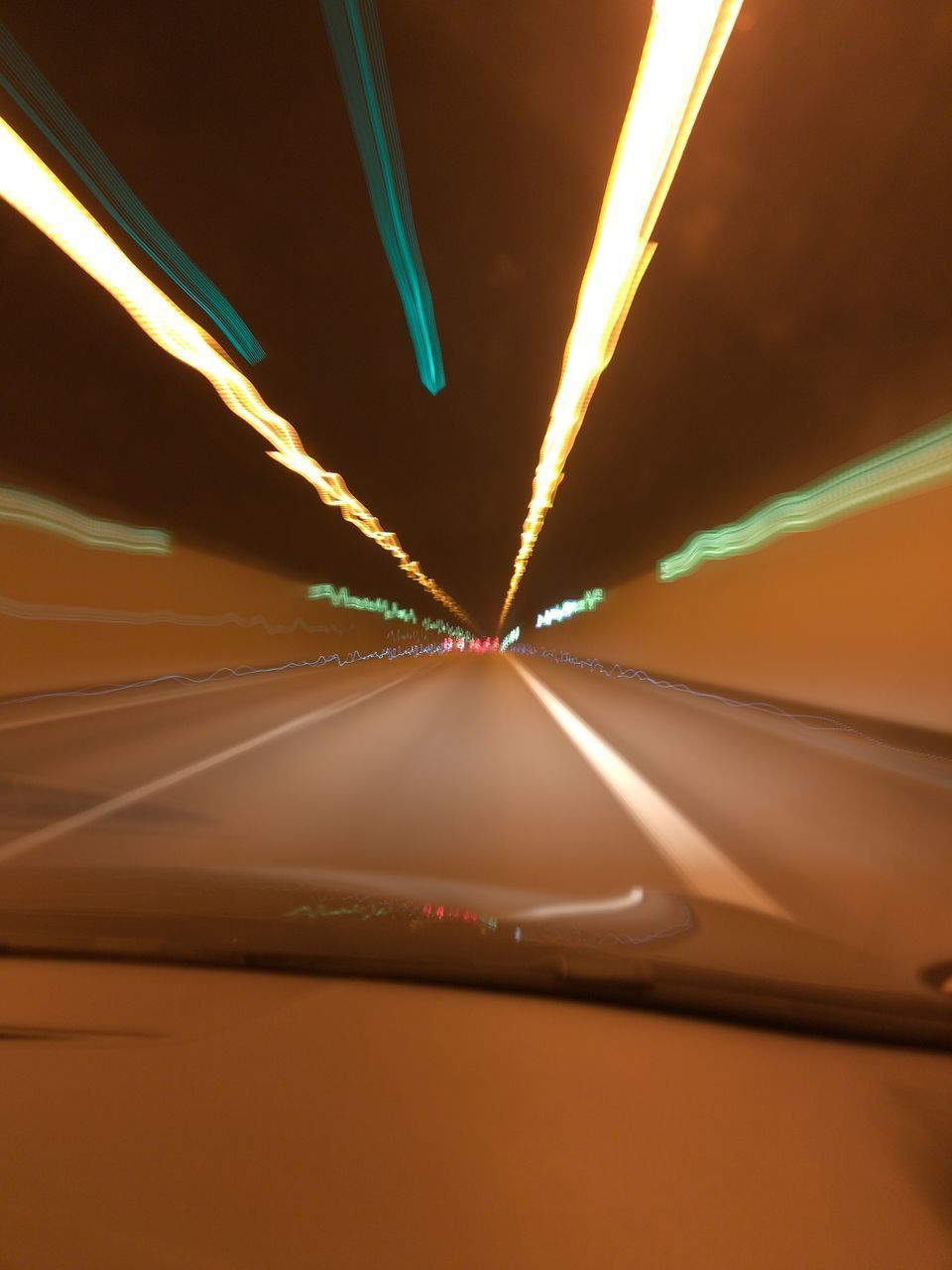 ILLUMINATED ROAD SEEN THROUGH CAR WINDSHIELD