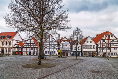 Houses by street against sky in city