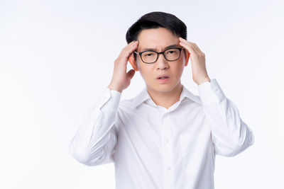 Portrait of young man standing against white background