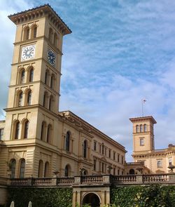 Low angle view of clock tower against cloudy sky