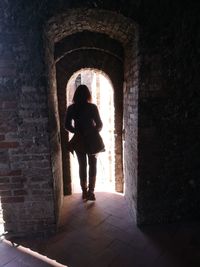 Rear view of man and woman walking in corridor