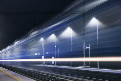 Light trails on railroad station platform at night