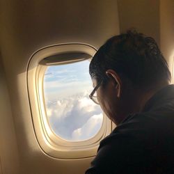 Portrait of man looking through airplane window