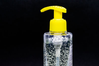 Close-up of yellow bottle against black background