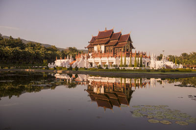 Building by lake against sky