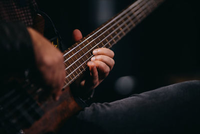 Close up man playing bass guitar