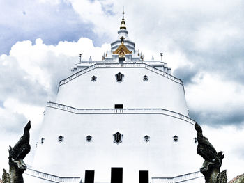 Low angle view of cross and building against sky