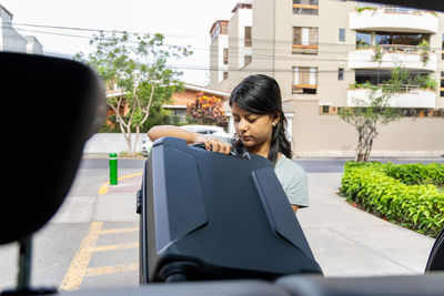 Side view of young woman using mobile phone