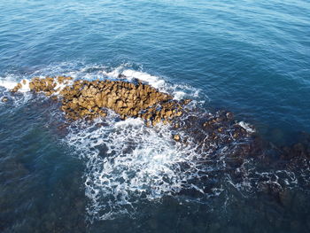 High angle view of rocks on sea shore
