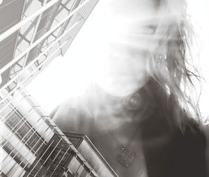 Low angle view of woman standing against built structure