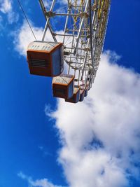 Low angle view of ferris wheel against blue sky