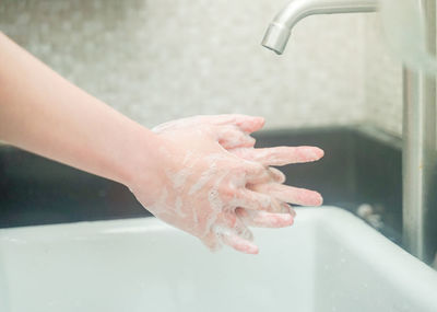 Midsection of woman in bathroom at home