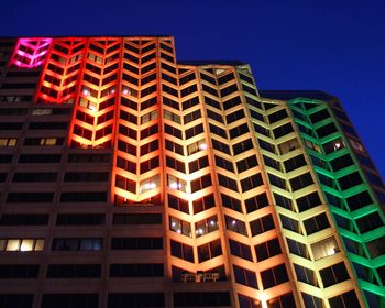 Low angle view of skyscraper against clear sky at night