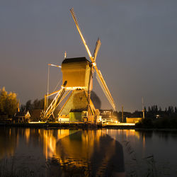 Cranes by river against sky